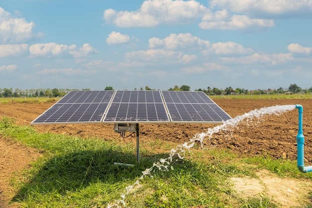 Solar panel connected to a water pump irrigating a field, used for a solar-powered drip irrigation system